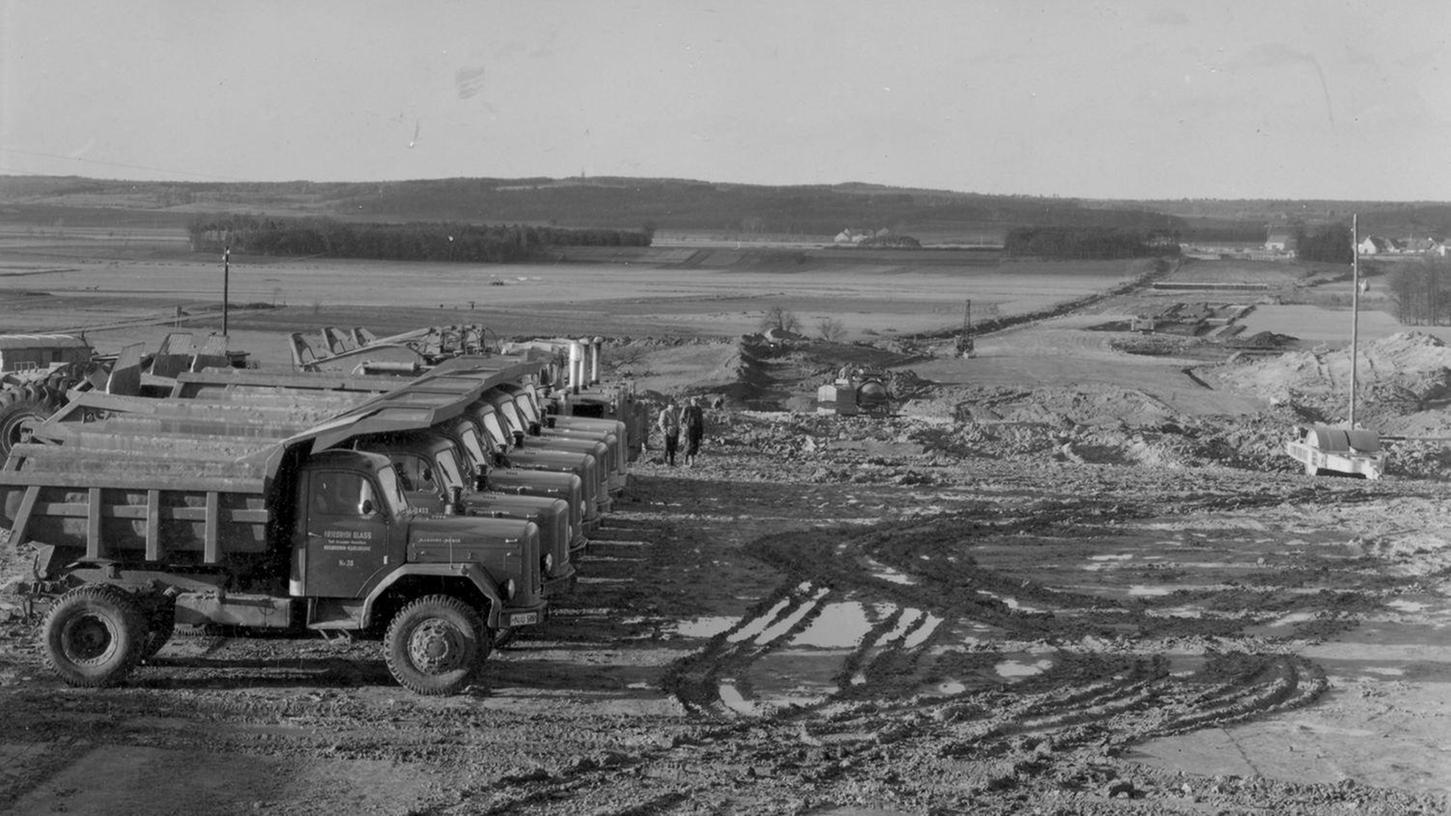 In den 1960er Jahren: Lastwagen warten auf ihren Einsatz bei Höchstadt. Man erkennt im Hintergrund die Medbacher Mühle und Medbach. 
