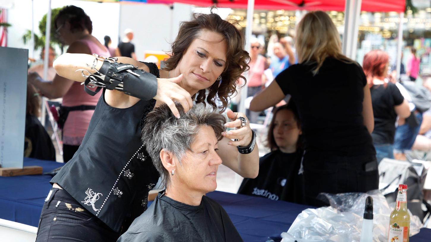 Benefiz-Aktion für die Aids-Hilfe: Friseur-Weltmeisterin Sonja Fischer schneidet Manuela Praskalo die Haare.