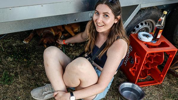 Bei 30 Grad im Schatten verschwindet Frau im Schatten und streichelt den Veranstalterhund, der unter dem Produktionsanhänger liegt.