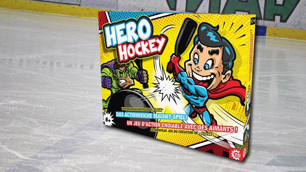 "Hero Hockey" ist ein Zwei-Personen-Spiel, das sich von selbst erklärt, denn es geht darum, einen Ball auf das gegnerische Tor zu schießen. Dazu dienen magnetische Figuren, die sich auf einem auf Stellfüßen stehenden Spielfeld befinden. Sie werden über Halter an der Unterseite des Feldes bewegt und sind mit Stangen ausgestattet, die als Hockeyschläger dienen. Spannend ist: Wie gut ist die gegnerische Abwehr, und wann gelingt der erste Treffer? Tatsächlich bekommt man immer dann einen Punkt, wenn man ein Tor schießt oder der Gegner die Kontrolle über seine Figur verliert. Fazit: ein lustiges Spiel voller Action für Geschickte und Glückspilze. "Hero Hockey" von Alexander Fuhrer und Mikkel Bertelsen, erschienen bei Game Factory, ca. 37 Euro.