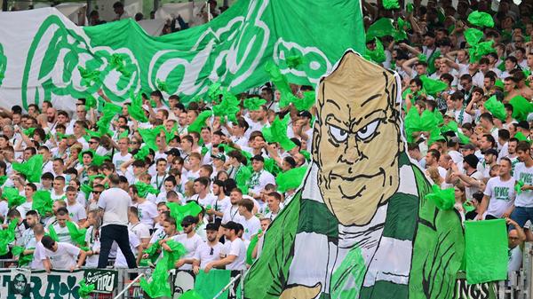 "Alle in weiß", lautete das Motto der Kleeblatt-Anhänger vor dem sommerlichen Gastspiel in Nürnberg. Einzig die Spruchbänder sowie ein Choreo-Element, das einen Fürth-Fan mit Schal zeigte, und die Rauchtöpfe setzten einige grüne Akzente im ansonsten weiß geprägten Gästeblock.