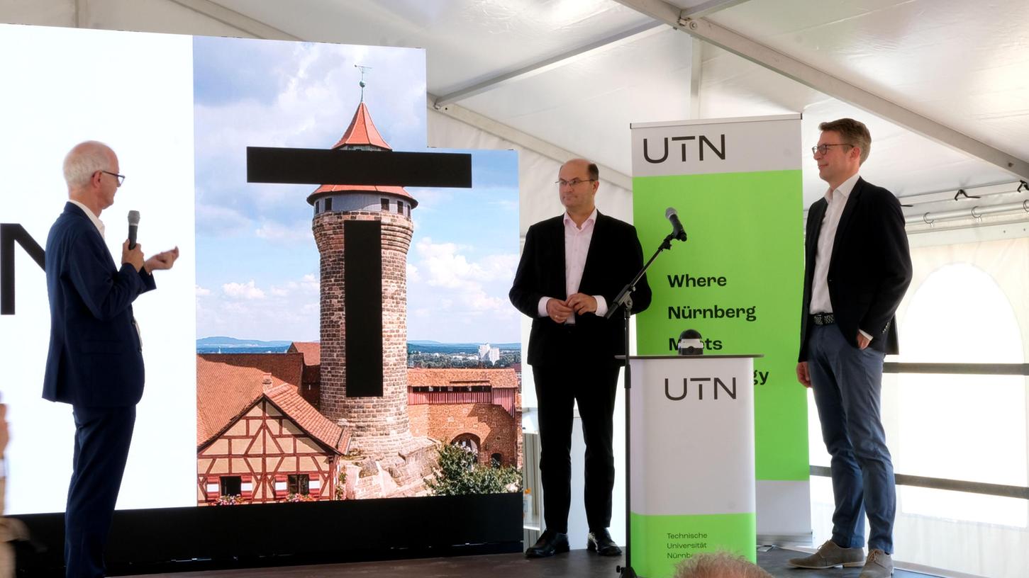 Präsident Hans Jürgen Prömel erklärt den Ministern Albert Füracker und Markus Blume: Das T der Technischen Universität soll den Sinnwellturm der Nürnberger Burg symbolisieren.