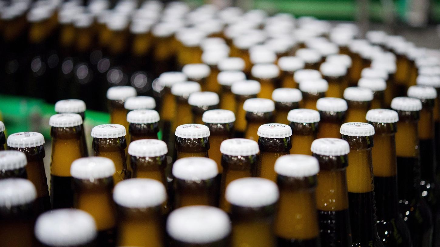 Bierflaschen mit Kronkorken laufen durch die Produktion einer Brauerei. Die weltweite Bierproduktion könnte im laufenden Jahr zurückgehen. Bierflaschen mit Kronkorken laufen durch die Produktion einer Brauerei. Die weltweite Bierproduktion könnte im laufenden Jahr zurückgehen.