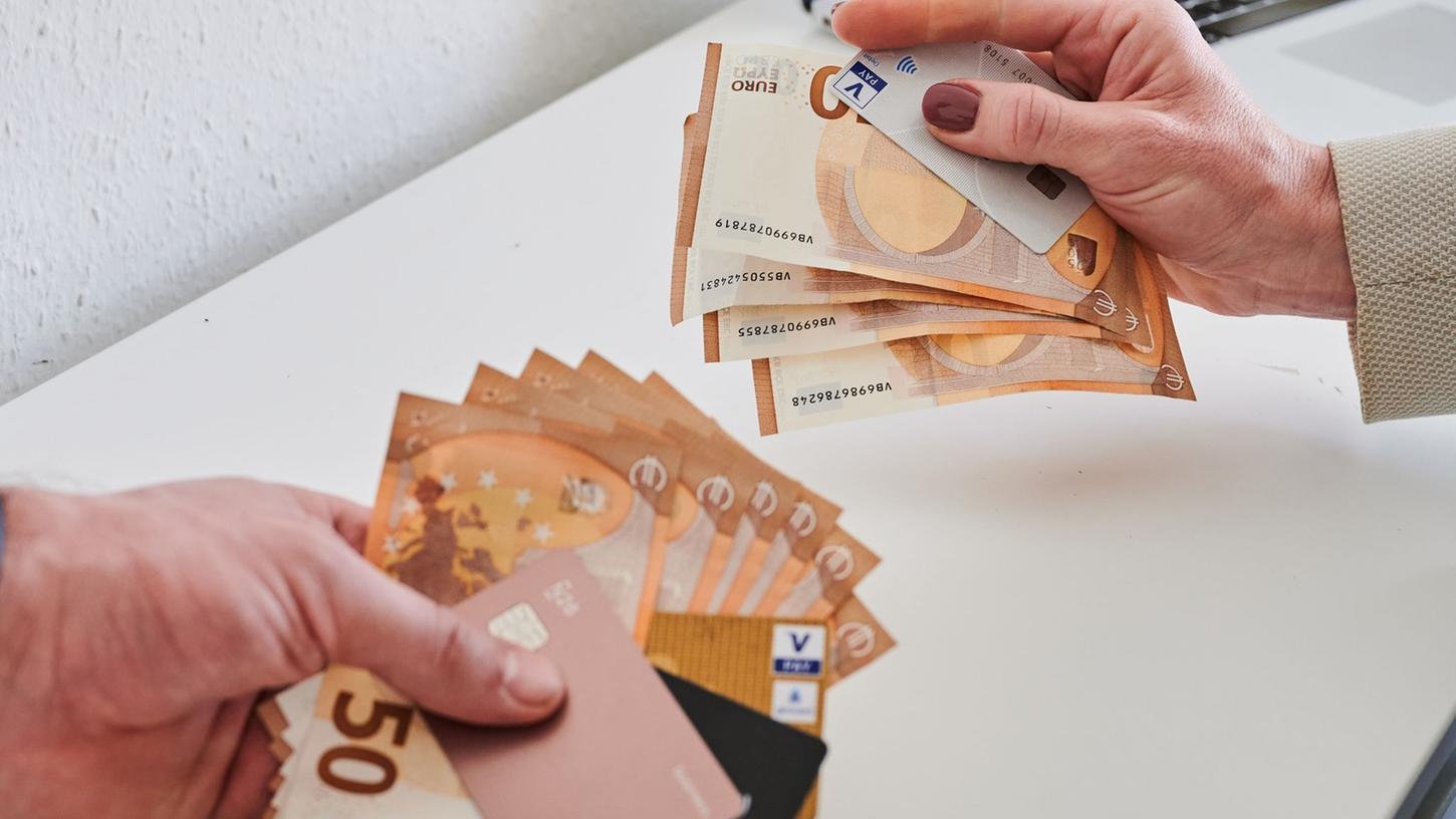 Ein Mann und eine Frau halten Geldscheine und Bankkarten in der Händen. Ein Mann und eine Frau halten Geldscheine und Bankkarten in der Händen.