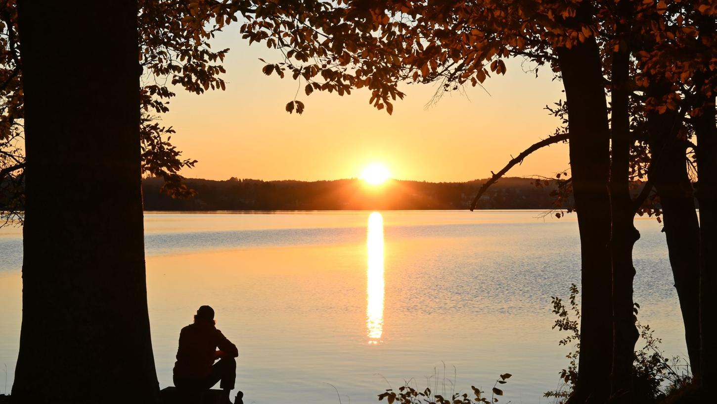 Ein Mann sitzt am Ufer des Starnberger Sees. Mit den eigenen Gedanken alleine zu sein finden viele Menschen angenehmer als vermutet.