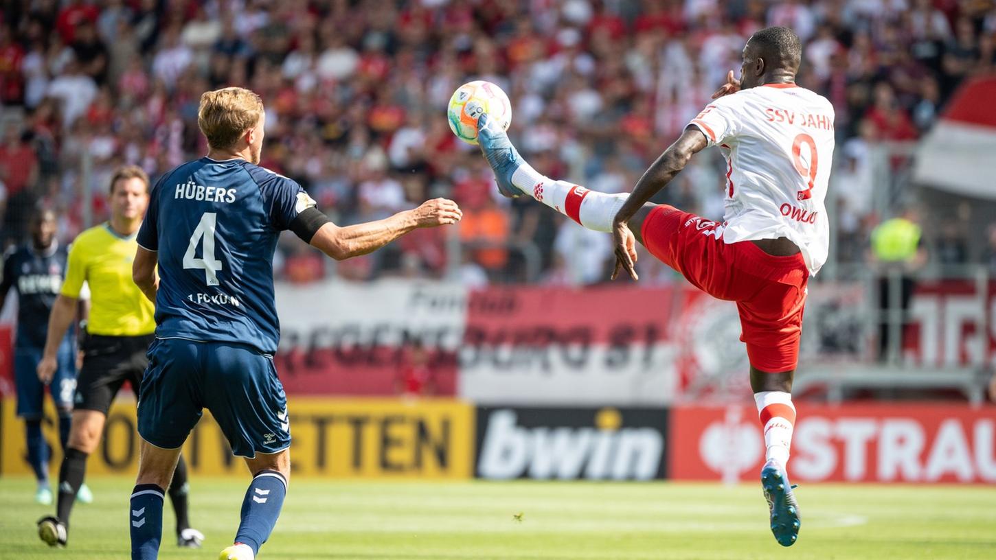 Kölns Timo Hübers (l) und Regensburgs Prince Osei Owusu im Zweikampf um den Ball. Kölns Timo Hübers (l) und Regensburgs Prince Osei Owusu im Zweikampf um den Ball.