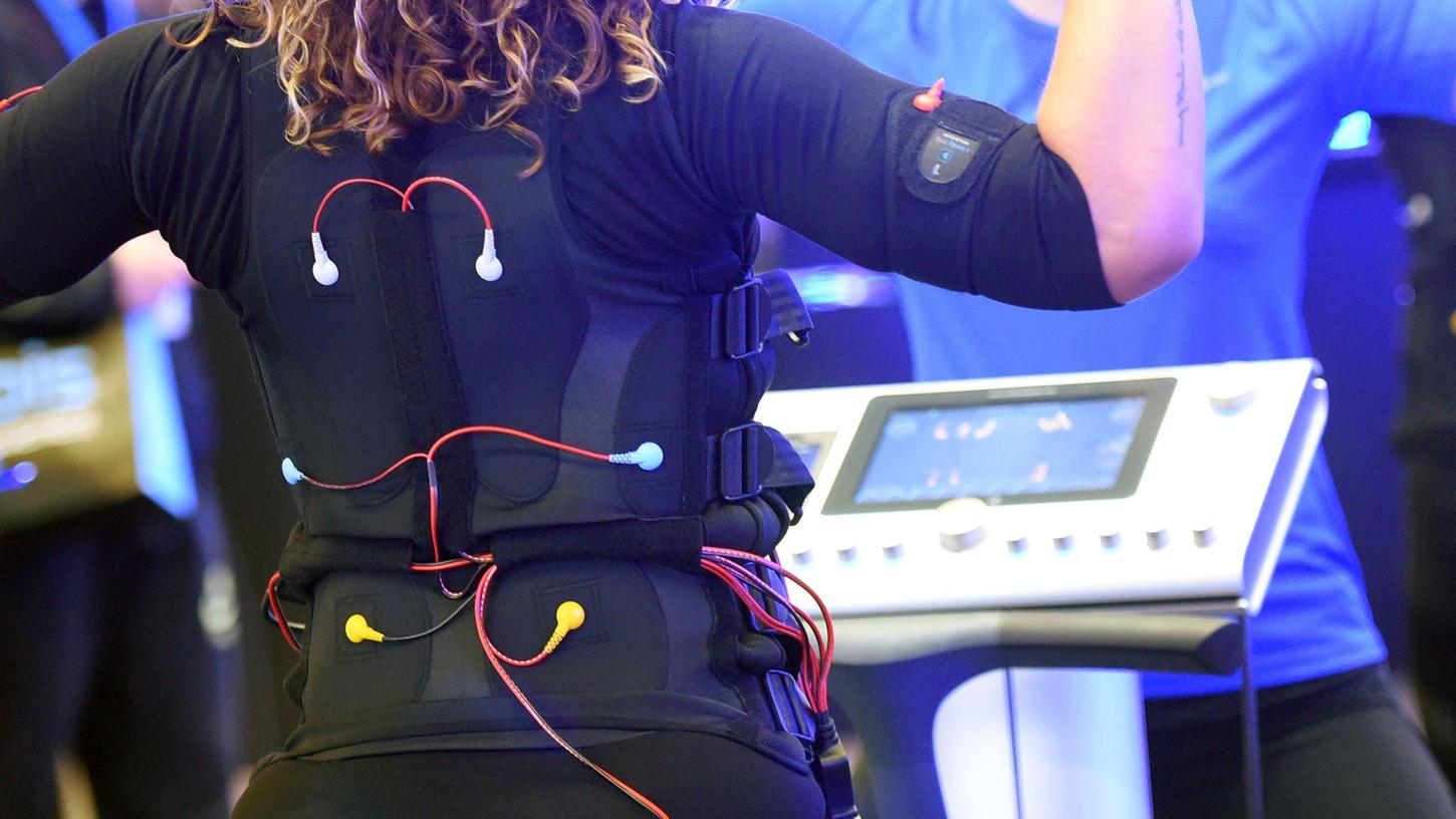 Bei einem EMS-Training trägt man eine verkabelte Weste und Manschetten, über die elektrische Impulse an den Körper weitergeleitet werden. Bei einem EMS-Training trägt man eine verkabelte Weste und Manschetten, über die elektrische Impulse an den Körper weitergeleitet werden.