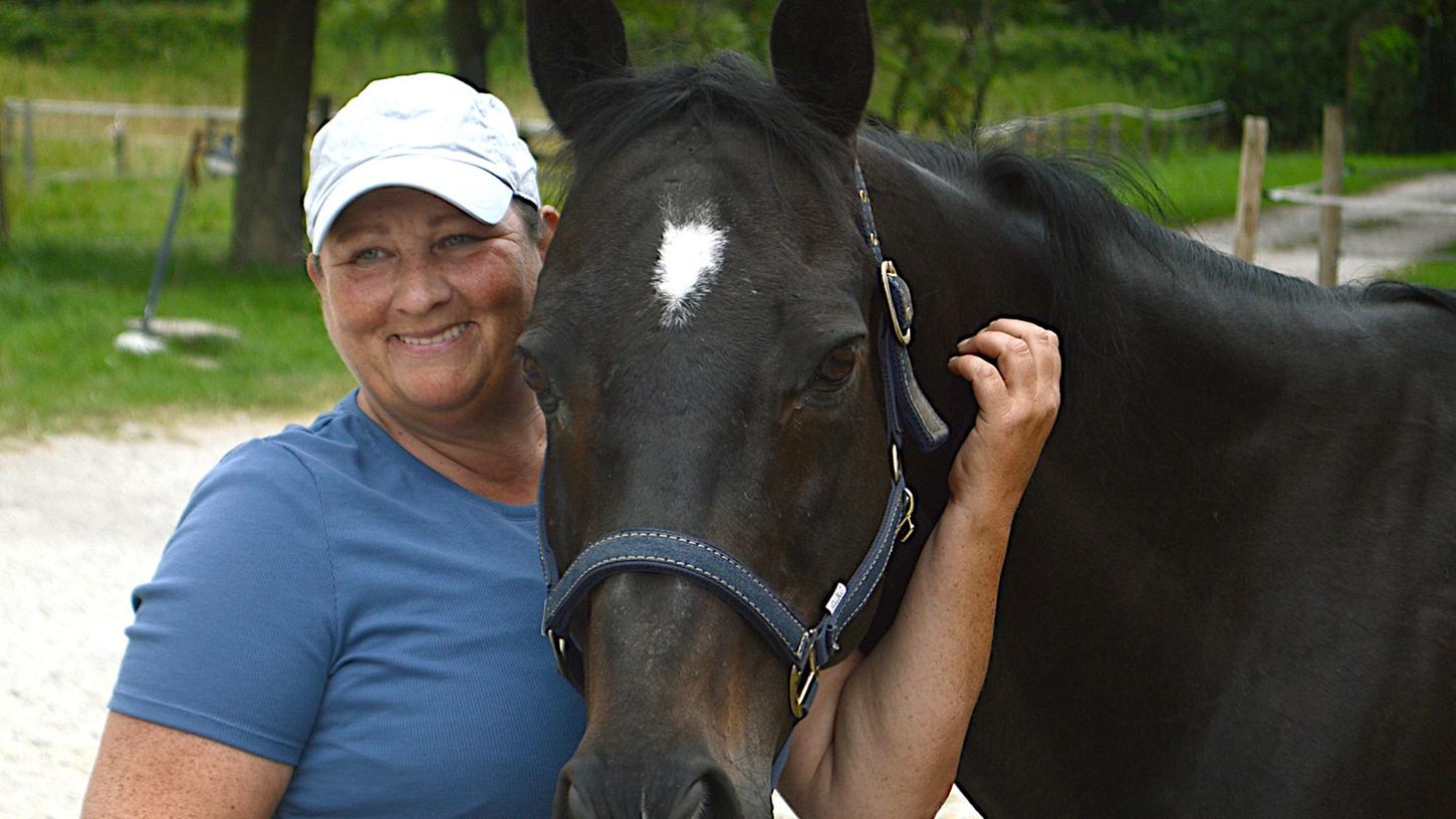 Trainerin Anke Dahlhaus umarmt ein Pferd. In anderen Ländern sind Umschulungsstätten für ehemalige Rennpferde gang und gebe - in Deutschland gibt es nur eine.