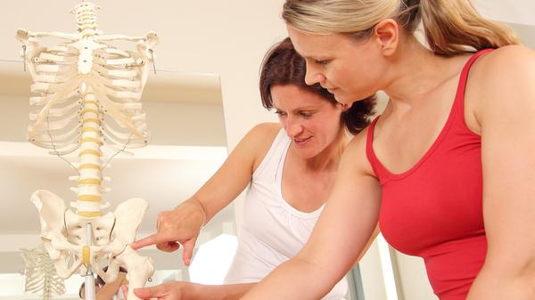 Spezialistin erklaert Patientin Huefte