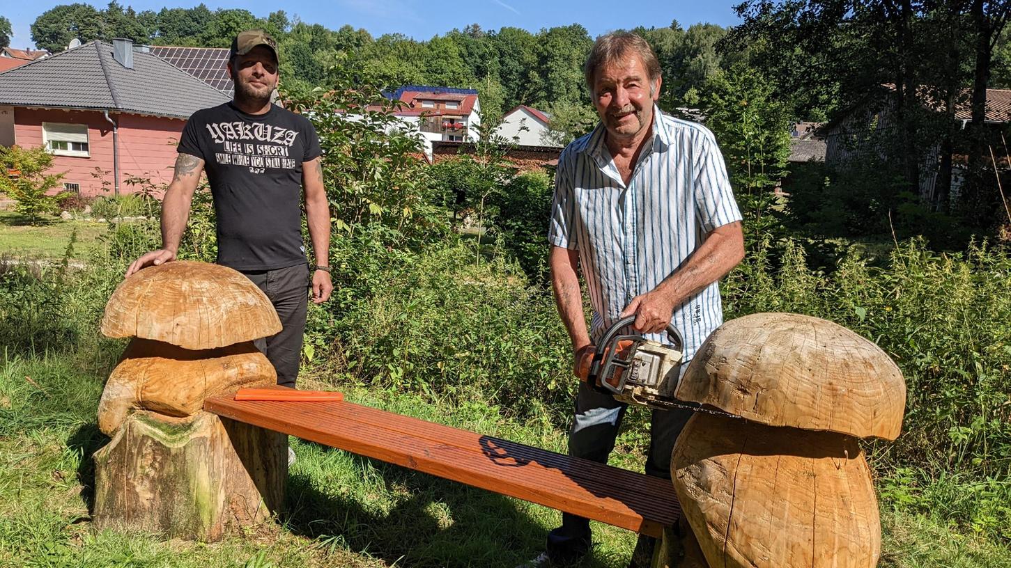 Der Degelsdorfer Zimmermann Peter Ziegler (re.) schnitzte zusammen mit Sohn Markus Ziegler - ebenfalls Zimmermann - diese Holzbank mit Pilz-Wangen und stellte sie am Mühlenweg auf. Foto: Frank Heidler
Der Degelsdorfer Zimmermann Peter Ziegler (re.) schnitzte zusammen mit Sohn Markus Ziegler - ebenfalls Zimmermann - diese Holzbank mit Pilz-Wangen und stellte sie am Mühlenweg auf. Foto: Frank Heidler