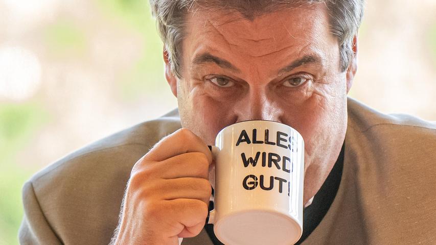 Markus Söder (CSU), Ministerpräsident von Bayern, nimmt an der letzten bayerischen Kabinettssitzung vor der Sommerpause teil und trinkt aus einer Tasse mit der Aufschrift "Alles wird gut !".
