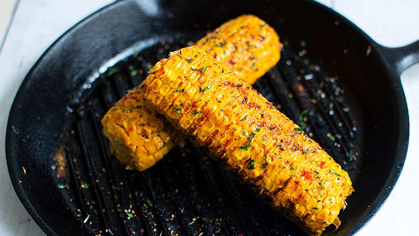 Gegrillte Maiskolben mit einer raffinierten Miso-Butter, die den gelben Körnern einen leicht salzigen Umami-Geschmack verleiht. Gegrillte Maiskolben mit einer raffinierten Miso-Butter, die den gelben Körnern einen leicht salzigen Umami-Geschmack verleiht.