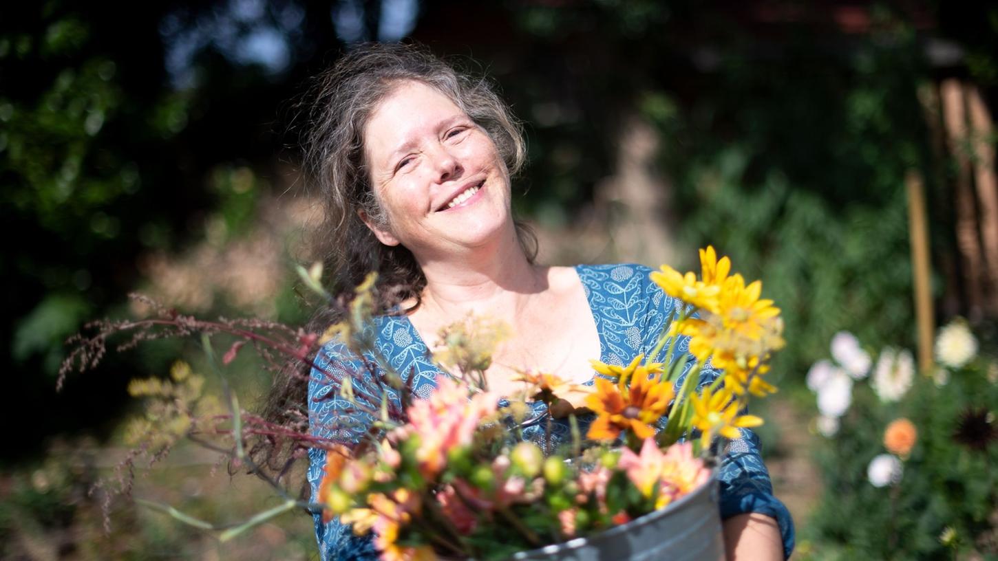 Claudia Werner steht mit einem Eimer mit frisch geschnittenen Blumen in ihrem Garten. Früher arbeitete die Bremerin als Erzieherin - heute hat sie eine eigene Gärtnerei. Claudia Werner steht mit einem Eimer mit frisch geschnittenen Blumen in ihrem Garten. Früher arbeitete die Bremerin als Erzieherin - heute hat sie eine eigene Gärtnerei.