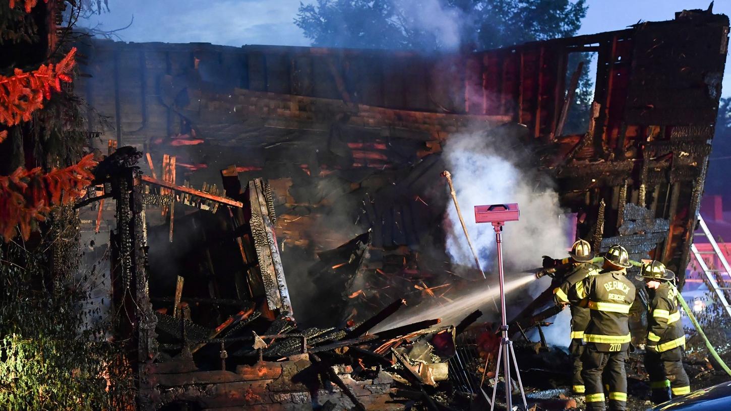 Feuerwehrleute an der Brandruine des Hauses, das während eines tödlichen Brandes einstürzte.