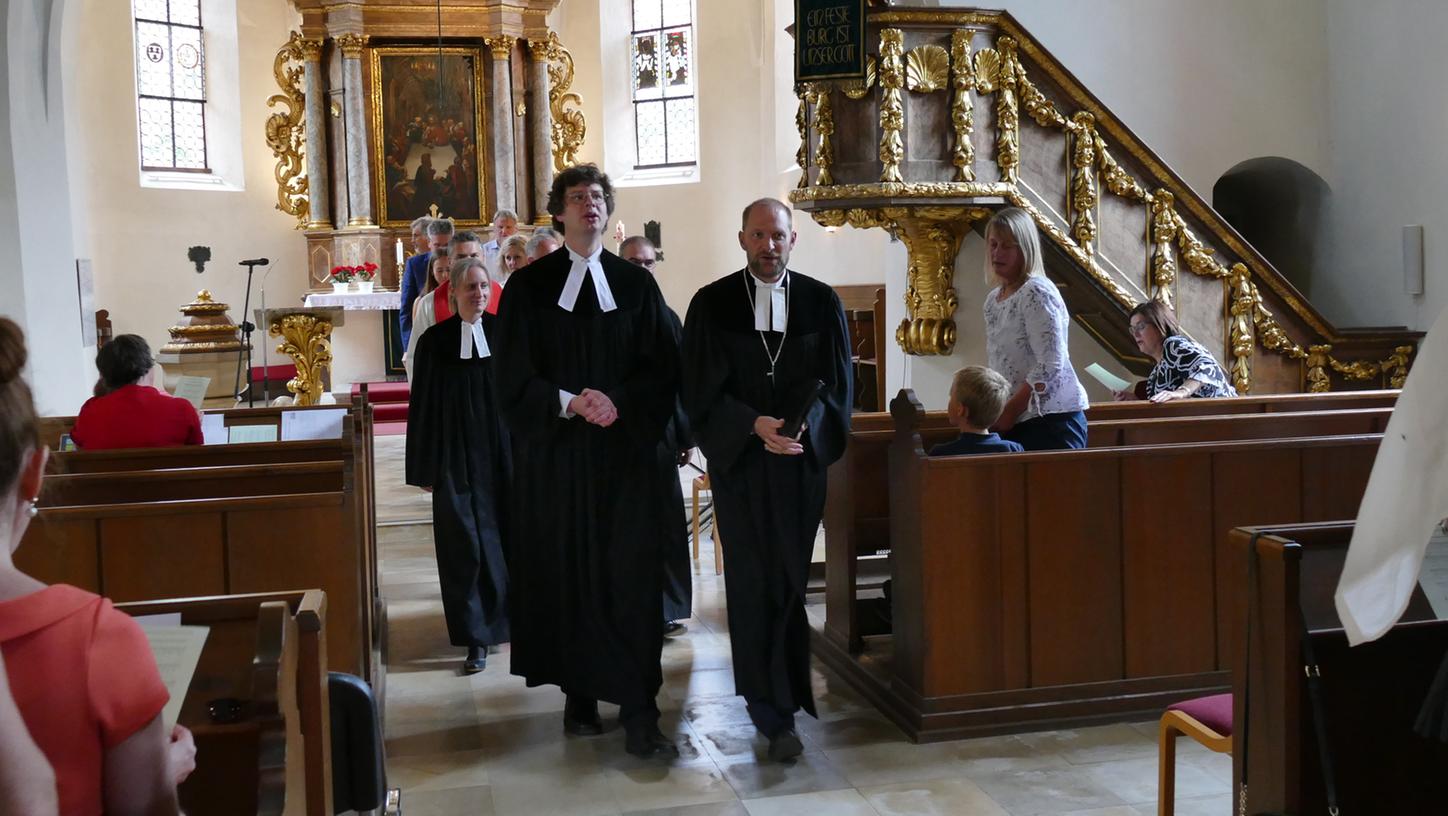 Dekan Tobias Schäfer (rechts) begleitet Pfarrer Gottfried Kaeppel bei seinem letzten Gottesdienst aus der Kirche hinaus.