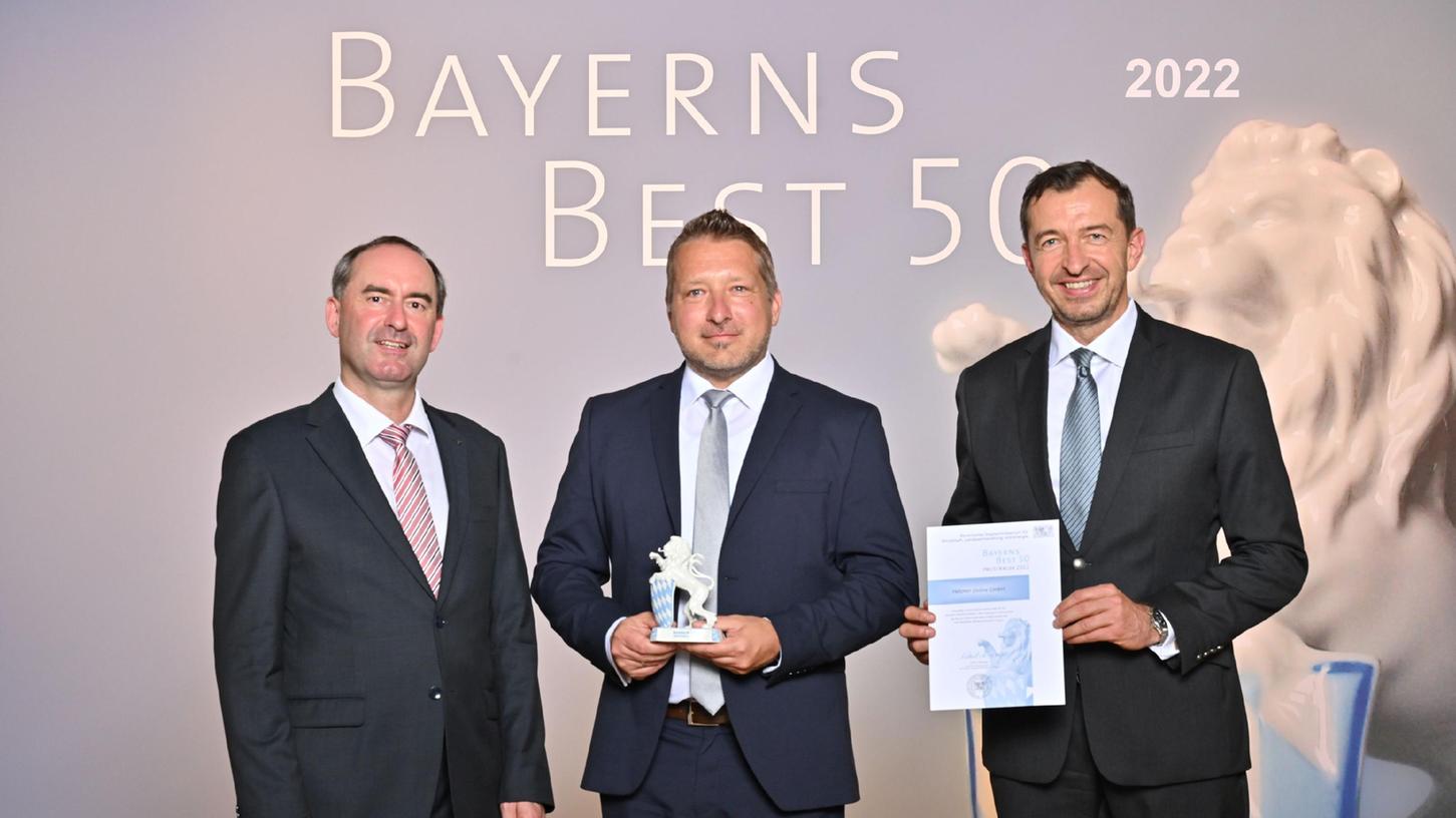 Wirtschaftsminister Hubert Aiwanger (links) und Juror Stefan Schmal (rechts) überreichten die Auszeichnung „Bayerns Best 50“ an den PR-Manager von Hetzner Online, Christian Fitz.