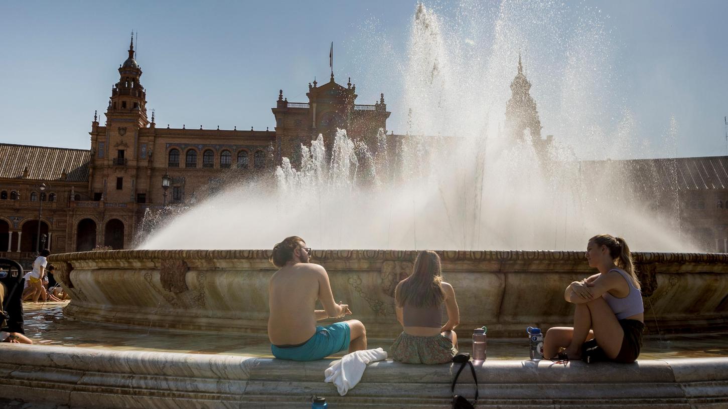 Touristen erfrischen sich im Brunnen der Plaza de España in Sevilla: Ab Herbst ist die andalusische Stadt per Flugzeug von Nürnberg aus direkt erreichbar..