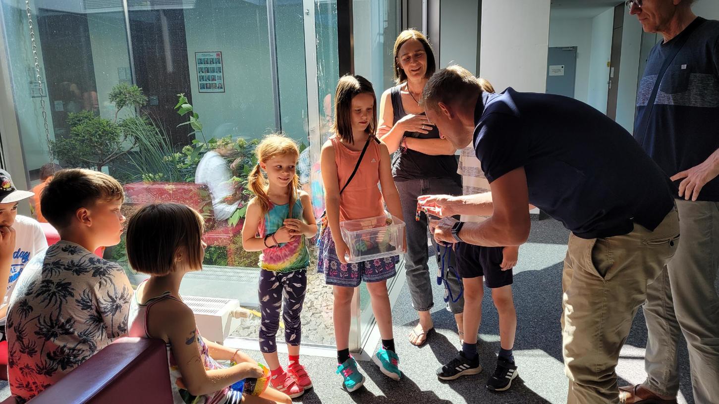 Bei der Spendenübergabe im Rathaus zeigen die Kinder der Gruppe "Netz für Kinder" Bürgermeister Volleth ihre Kunstwerke, die sie gewinnbringend vom Fenster ihres Hortes aus verkaufen konnten.
