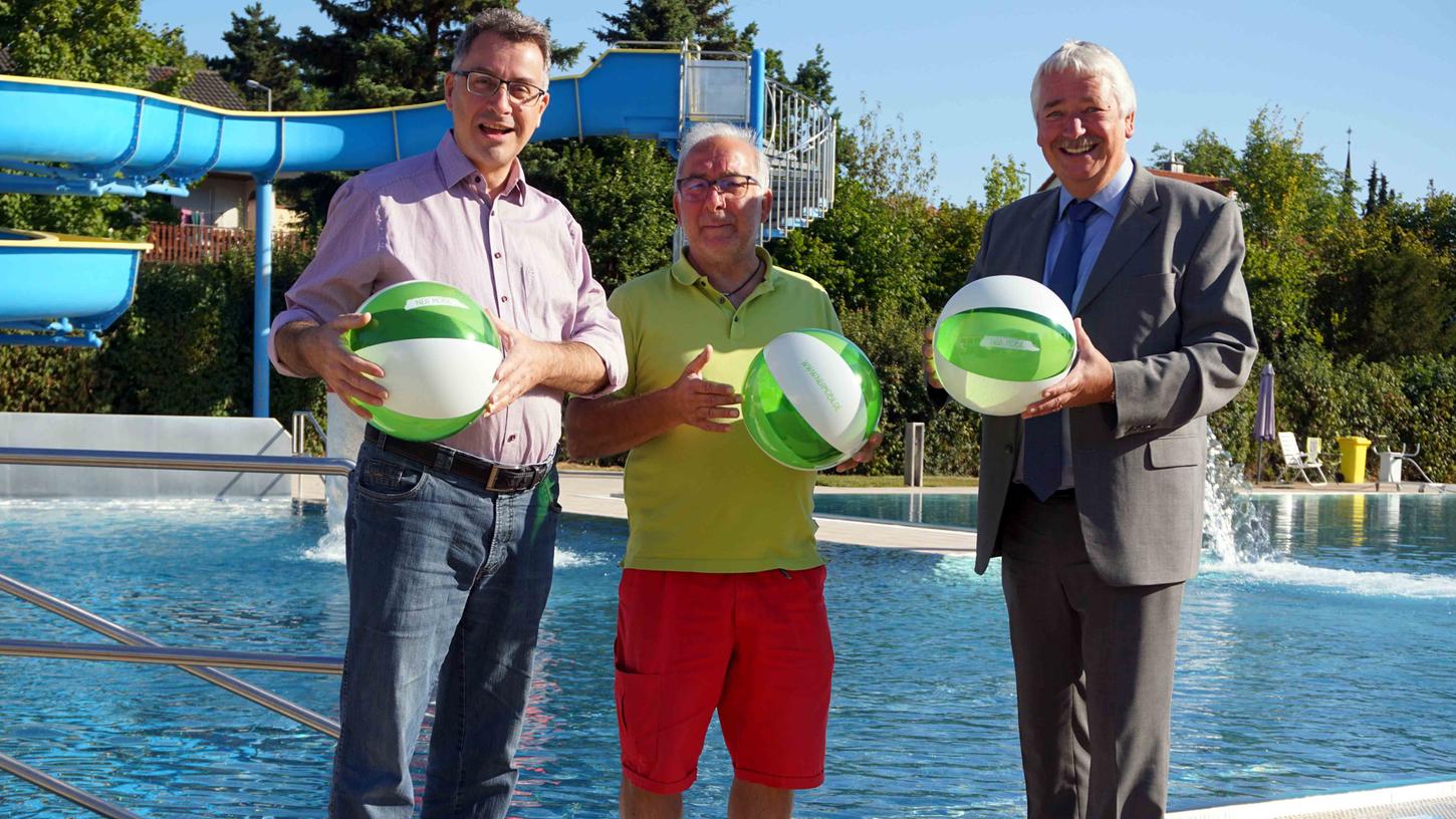 Bürgermeister Wolfgang Lampe, Mathias Nestmeier und stellvertretender Landrat Reinhard Streng (von links) mit drei der NEA-Mobil-Wasserbälle im Uffenheimer Freibad.