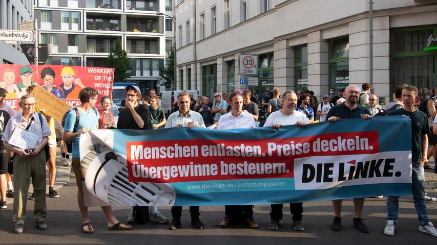 17.08.2022, Berlin: Teilnehmer an der Demonstration "Lindner raus - Umverteilung jetzt!" stehen mit Plakaten an der FDP-Bundesgeschäftsstelle. Foto: Paul Zinken/dpa +++ dpa-Bildfunk +++