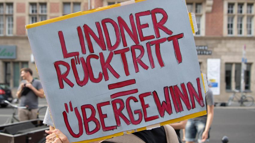 17.08.2022, Berlin: Ein Teilnehmer an der Demonstration "Lindner raus - Umverteilung jetzt!" steht mit einem Plakat vor der FDP-Bundesgeschäftsstelle. Foto: Paul Zinken/dpa +++ dpa-Bildfunk +++