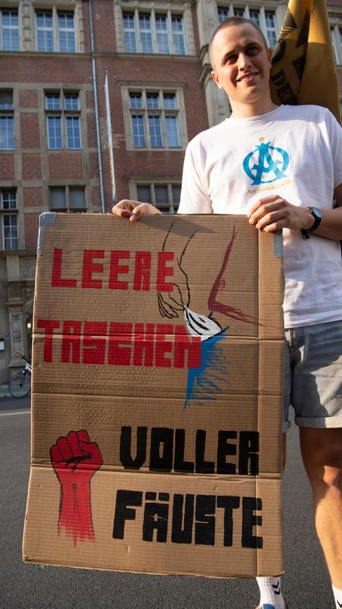 17.08.2022, Berlin: Ein Teilnehmer an der Demonstration "Lindner raus - Umverteilung jetzt!" steht mit einem Plakat vor der FDP-Bundesgeschäftsstelle. Foto: Paul Zinken/dpa +++ dpa-Bildfunk +++