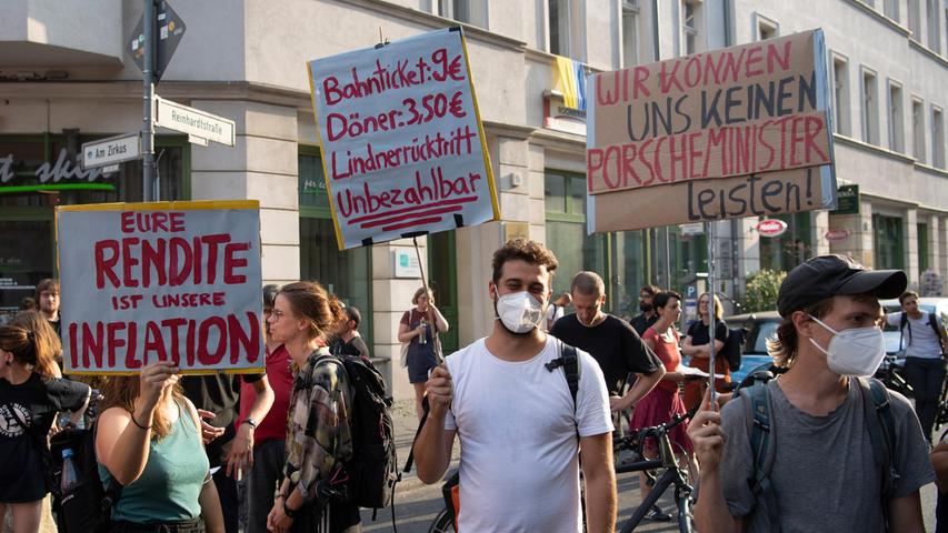 17.08.2022, Berlin: Teilnehmer an der Demonstration "Lindner raus - Umverteilung jetzt!" stehen mit Plakaten an der FDP-Bundesgeschäftsstelle. Foto: Paul Zinken/dpa +++ dpa-Bildfunk +++