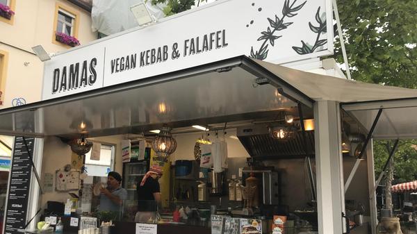 Direkt am Marktplatz bietet Kalil (im Bild vorne) seit zwei Jahren in seinem Foodtruck „Damas“ vegane Fast-Food-Leckereien an. „Besonders beliebt ist Falafel“, erzählt er, während er frisch frittierte und in Hummus gedippte Falafelbällchen an Kunden verteilt. Auch veganes Kebab – also Sojafleisch – werden angeboten.