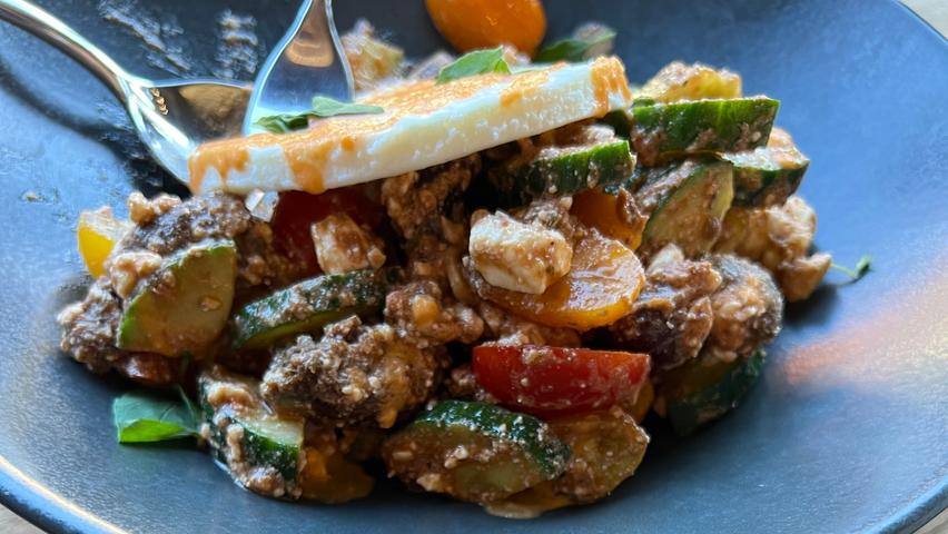 Der griechische Bauernsalat mit einem eleganten Dreh: Die Soße besteht aus getrockneten Tomaten, Zwieback aus Johannisbrotkernmehl sorgt für Knusper und getoppt wird das Ganze von einer dünnen Scheibe selbst gemachtem Feta.