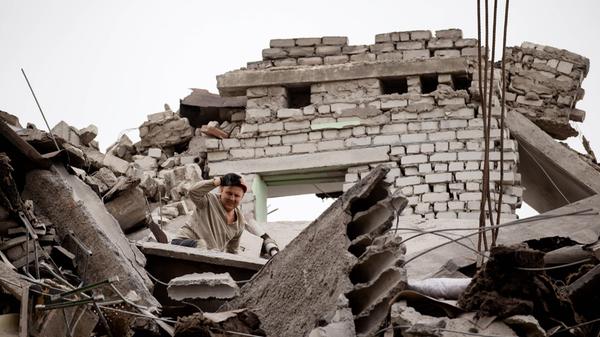 LUGANSK PEOPLE S REPUBLIC - AUGUST 26, 2022: A worker helps clear the rubble from the ruins of a building destroyed by a