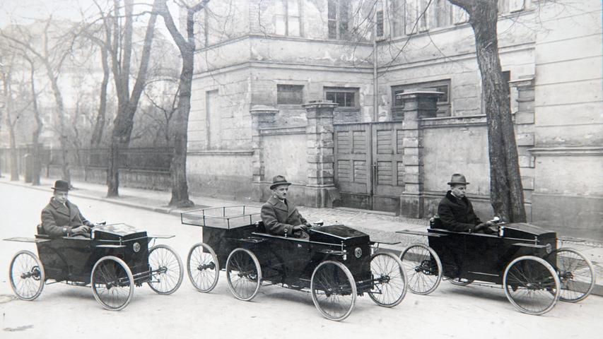 Eine undatierte historische Aufnahme zeigt zwei Slaby-Beringer SB-Elektrowagen und ein Fahrzeug mit Zusatzanhänger für weitere Personen. 