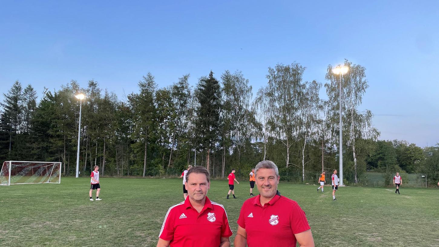 Sportlicher Leiter Marco Ringer und Vorsitzender Christian Koch freuen sich über die geschaffenen Bedingungen für ihre Fußballer. Im Hintergrund läuft das Training der ersten Mannschaft in den frühen Abendstunden bereits unter dem neuen Flutlicht.