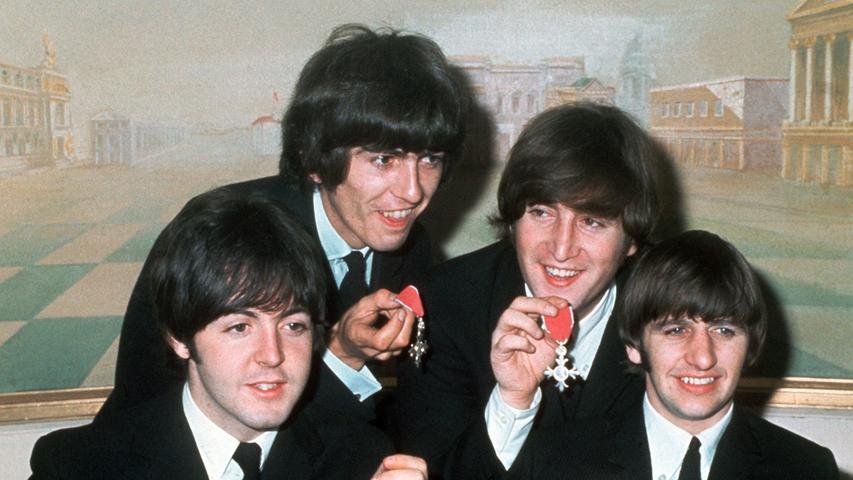 Die vier "Pilzköpfe" der britischen Popgruppe "The Beatles", l-r: Paul McCartney, George Harrison, John Lennon und Ringo Starr, präsentieren stolz ihre Orden "Member of the Order of the British Empire", die ihnen am 26. Oktober 1965 von Königin Elizabeth II. von Großbritannien verliehen worden waren.