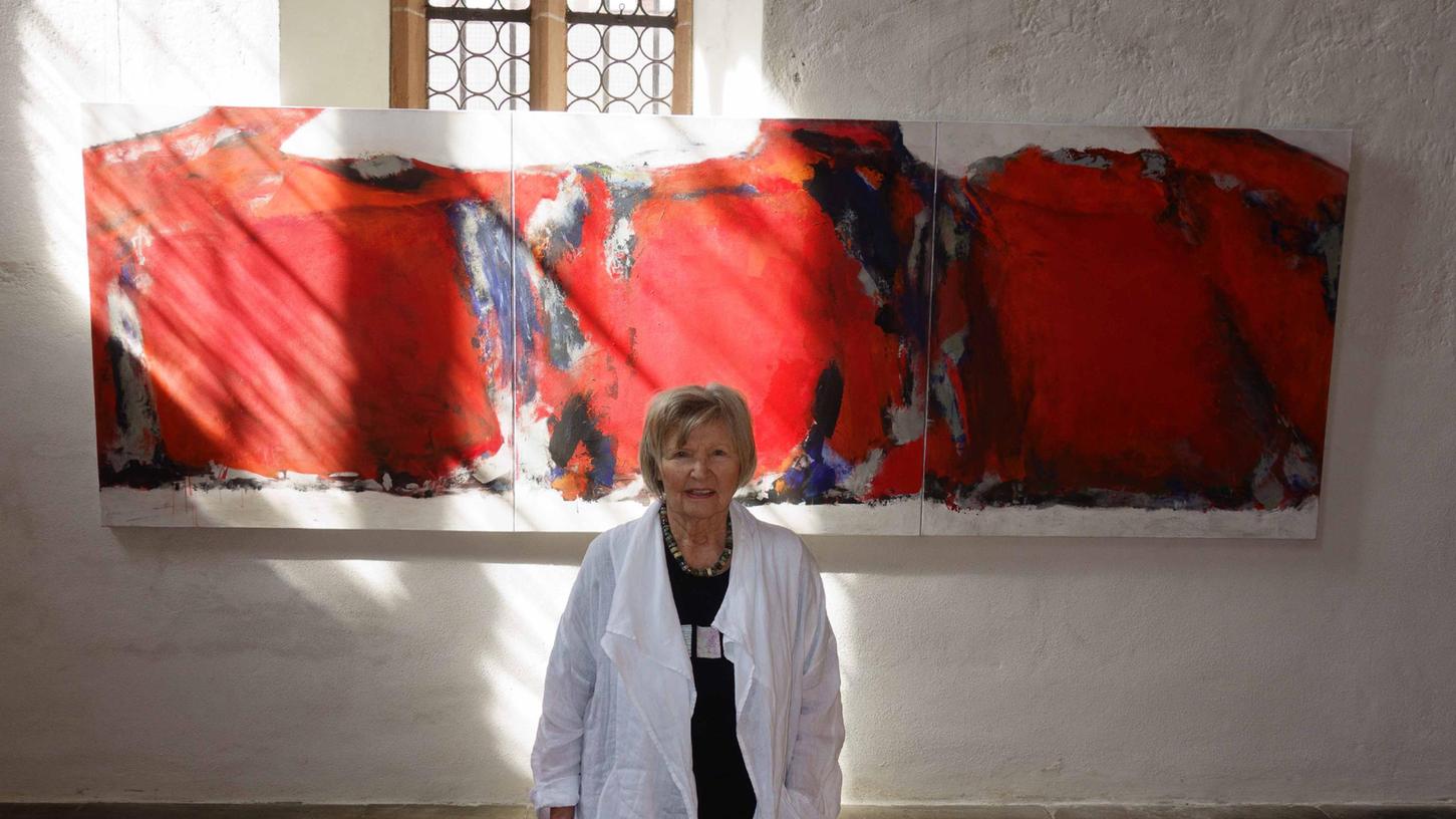 Anna-Luise Oechsler vor einem ihrer Werke. Die Farbe rot dominiert hier. 