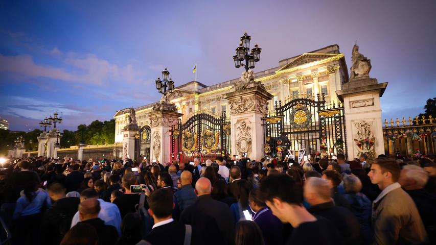 09.09.2022, Großbritannien, London: Hunderte Menschen gehen langsam am mit Blumen und Trauernachrichten geschmückten Haupteingang am Buckingham Palace vorbei. Die britische Königin Elizabeth II. ist am 08.09.2022 im Alter von 96 Jahren gestorben.