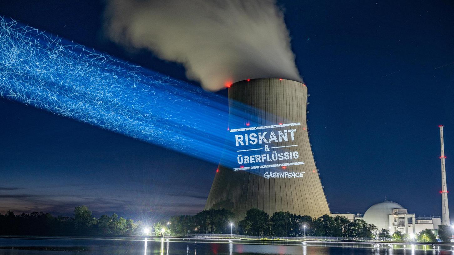 Greenpeace-Aktivisten projizieren "Riskant & überflüssig" an den Kühlturm am AKW Isar 2. Greenpeace-Aktivisten projizieren "Riskant & überflüssig" an den Kühlturm am AKW Isar 2.