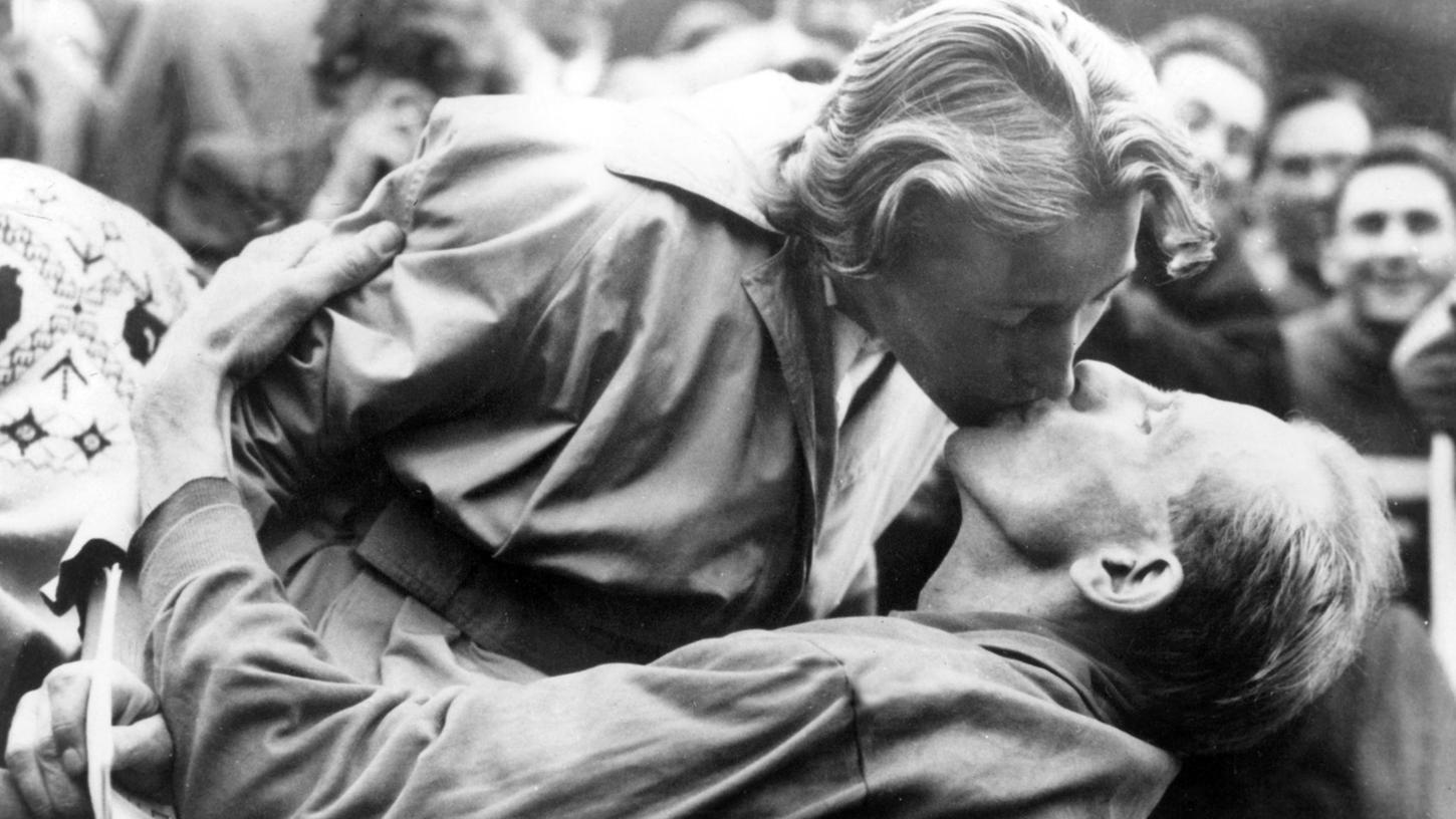 Emil Zatopek, der frischgebackene Olympiasieger im Marathonlauf, gibt kurz nach dem Überqueren der Ziellinie seiner Frau Dana Zatopkova einen Kuss. Emil Zatopek, der frischgebackene Olympiasieger im Marathonlauf, gibt kurz nach dem Überqueren der Ziellinie seiner Frau Dana Zatopkova einen Kuss.