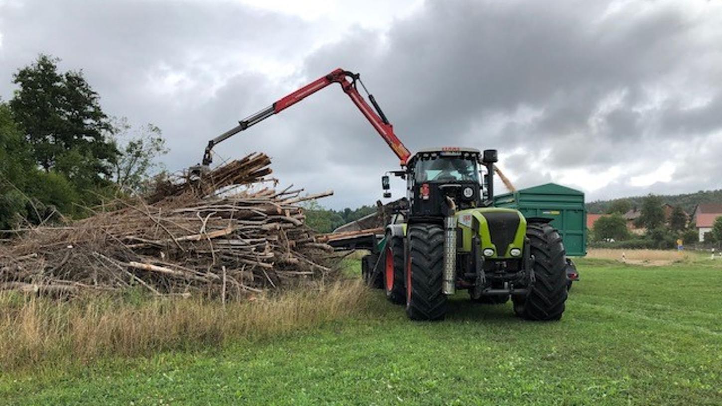 Aus Holz werden Hackschnitzel gehäckselt. Das Holz wird mit einem Kran und einer Zange in den Häcksler geschoben. Aus Holz werden Hackschnitzel gehäckselt. Das Holz wird mit einem Kran und einer Zange in den Häcksler geschoben.