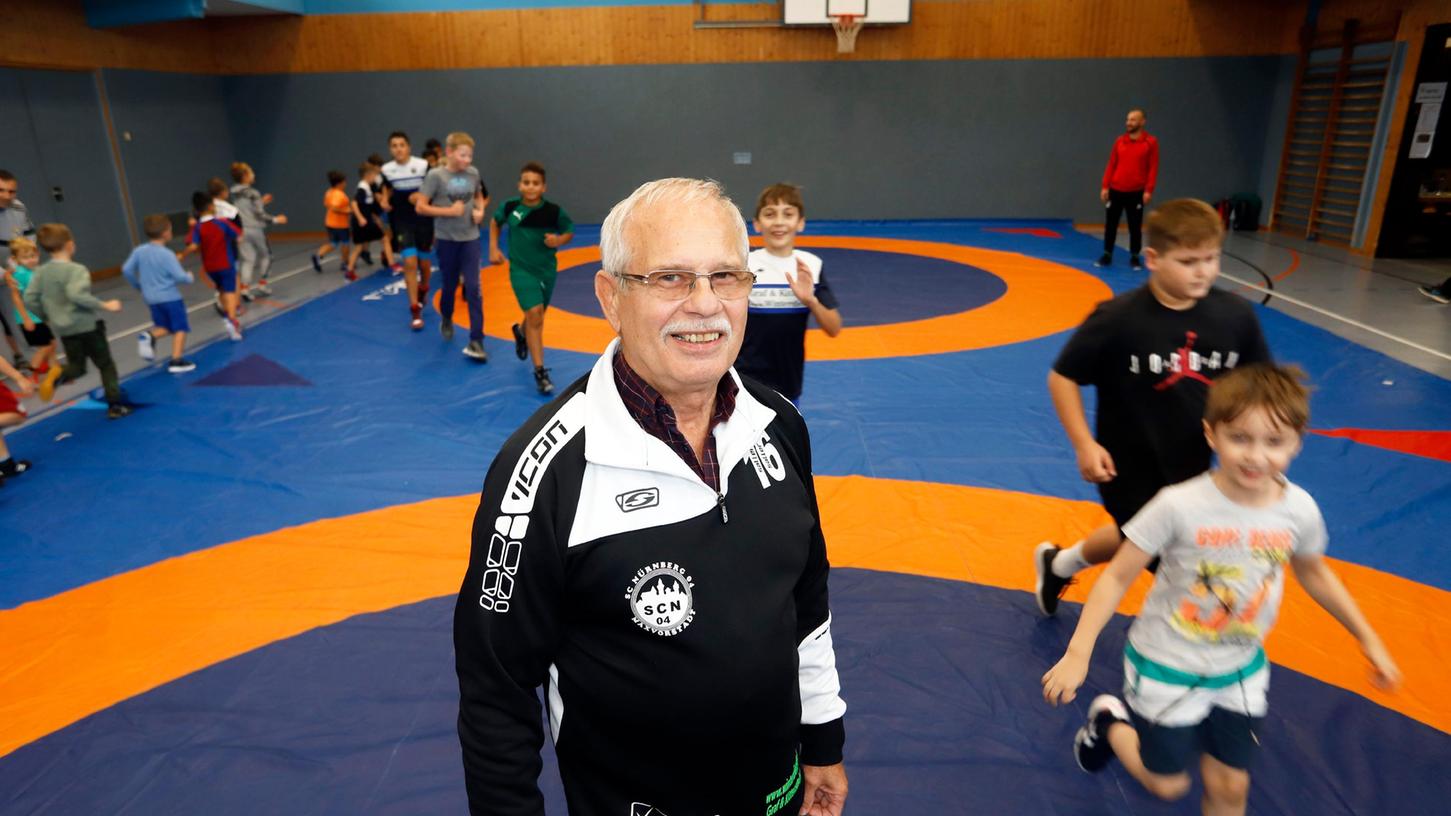 Ein Foto der Generationen: Vorne steht Walter Vogl (76) in der Halle des SC 04 Nürnberg, im Hintergrund machen sich Kinder für das Ringertraining warm - so wie er selbst in jungen Jahren.
Ein Foto der Generationen: Vorne steht Walter Vogl (76) in der Halle des SC 04 Nürnberg, im Hintergrund machen sich Kinder für das Ringertraining warm - so wie er selbst in jungen Jahren.
