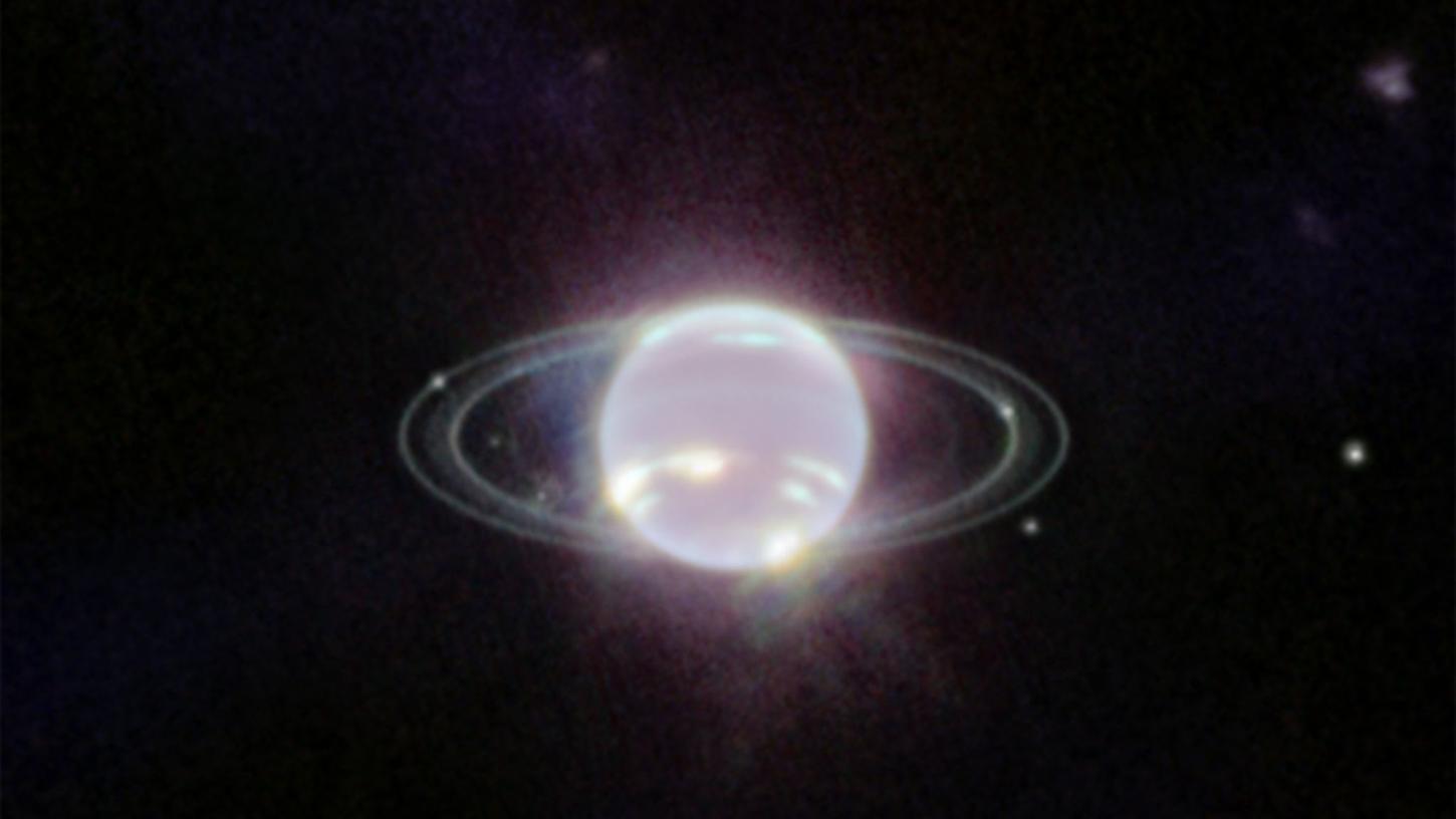 Der Planet Neptun schwebt im Zentrum einiger Ringe. Die Ringe wurden durch den Einsatz der Nahinfrarotkamera (NIRCam) zum ersten Mal seit mehr als drei Jahrzehnten in vollem Fokus sichtbnar.