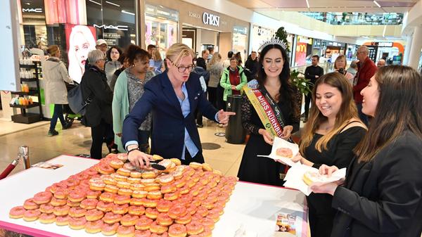 Die Erlangen Arcaden feiern "15 Jahre im Herzen der Stadt". Miss Bayern Carina Schätz und Moderator Constantin Greif verteilen Donats.