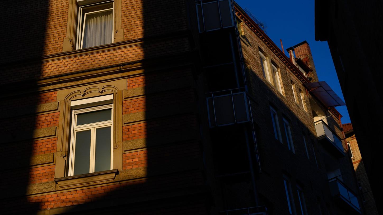 Die Sonne scheint zwischen zwei Häusern auf Fenster von Wohnungen.