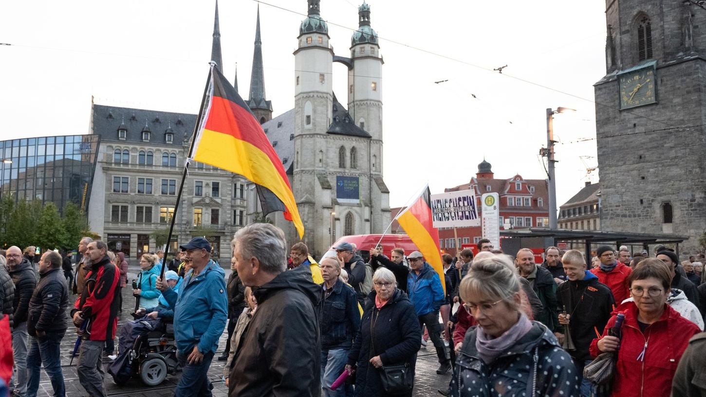 Teilnehmer einer Demonstration des Bündnisses "Bewegung Halle" ziehen durch Halle/Saale.