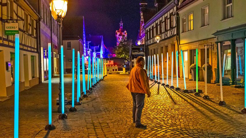 Ein Spalier verschiedenfarbig leuchtender Kunststoff-Stelen ziert zu "hin&herzo" die Hauptstraße.
