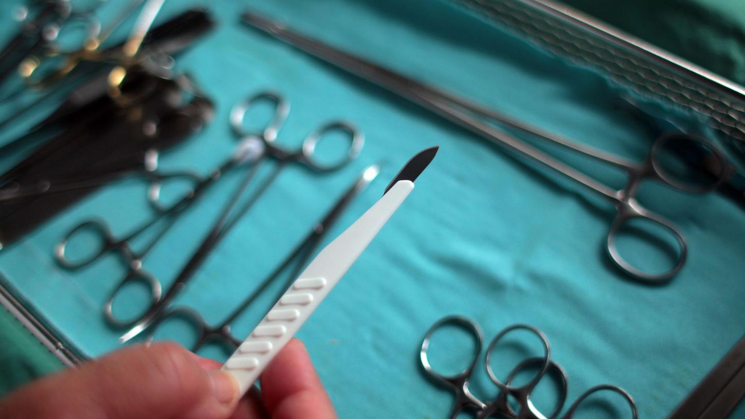 Der Chirurg hält im OP ein Skalpell in der Hand. (Archivbild)