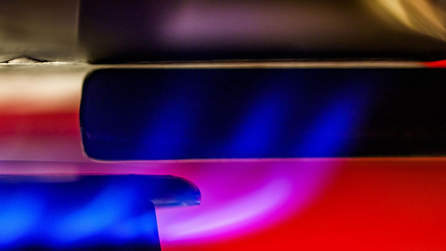 Eine Gasflamme erhitzt Wasser in einem Kochtopf. Eine Gasflamme erhitzt Wasser in einem Kochtopf.