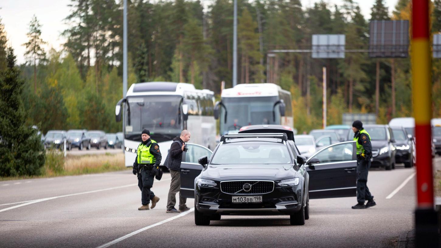 Autos und Busse stehen an der russisch-finnischen Grenze Schlange.