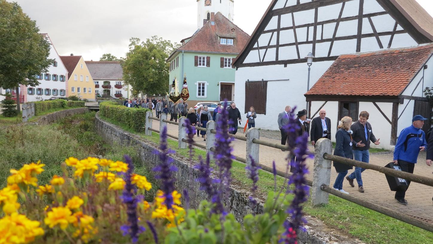 Viele Meinheimer machten sich zunächst mit der Landeskommission auf den Weg entlang dem Mühlbach, um markante Stellen und Gebäude im Ortskern anzuschauen. Die Baugestaltung war einer der Trümpfe, die der Ort ausspielen konnte.