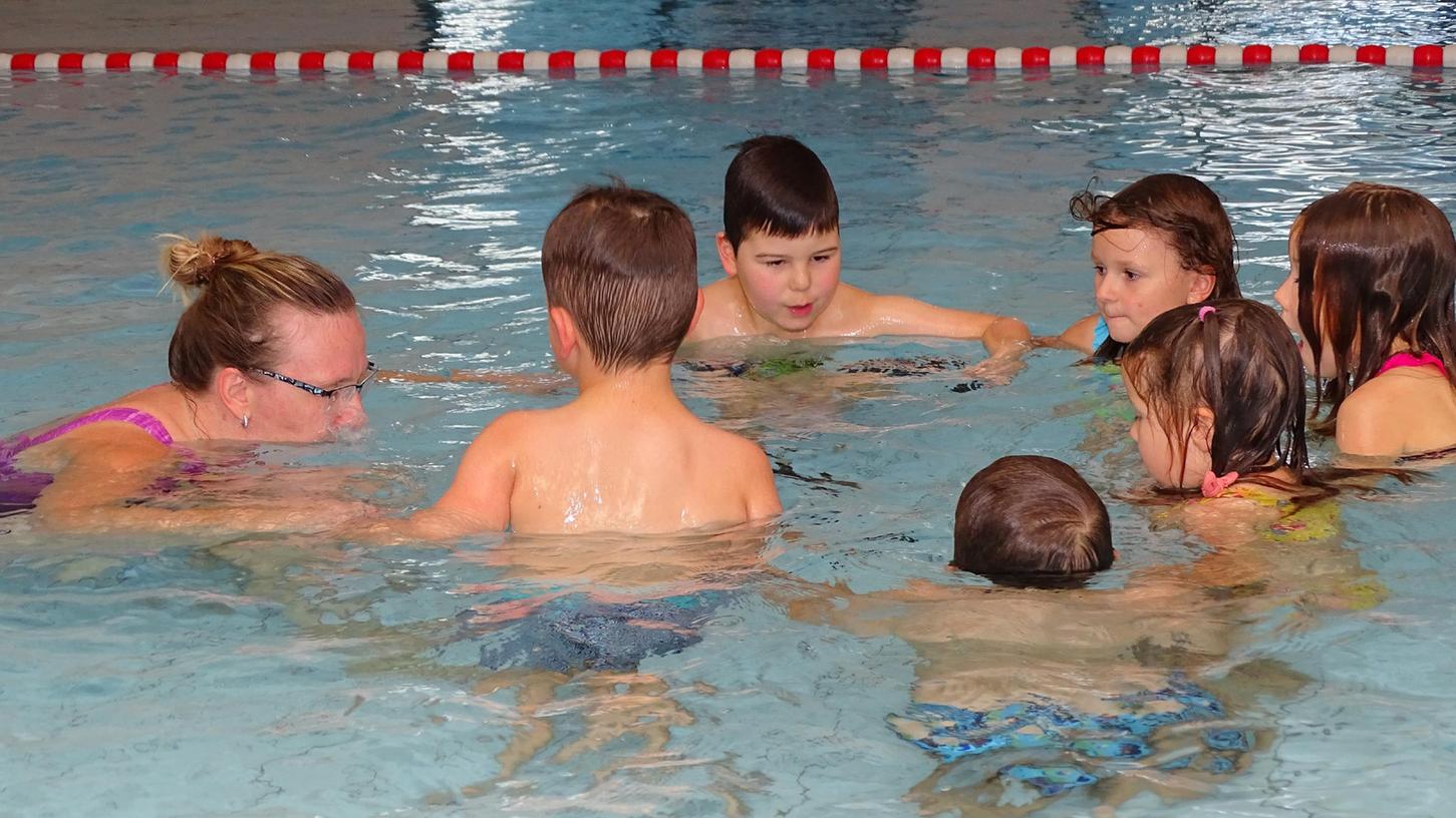 Mit Feuereifer bei der Sache: Schwimmlehrerin Kerstin Kleemann demonstriert wie man im Wasser prusten kann. Die Kinder machen es nach und lernen so es kennenzulernen und zu beherrschen.
