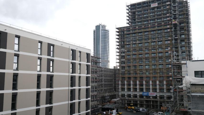 Links sind die geförderten Wohnungen zu sehen, rechts der Wohnturm mit den frei finanzierten Wohnungen. Hinten erkennt man den Business Tower der Nürnberger Versicherung. Die dazwischen verlaufende Ostendstraße soll abschnittsweise generalsaniert werden. Mehr Bäume soll es dort dann geben und auch einen Radweg.